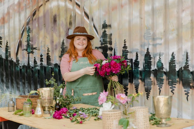Pic of a woman flower shop owner making a flower arrangement.