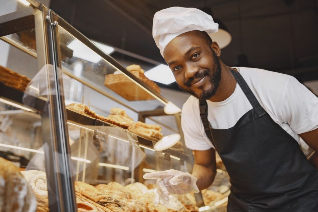 A successful baker in traditional attire presents a variety of fresh pastries at a bakery thanks to our effective Tampa Digital Marketing.